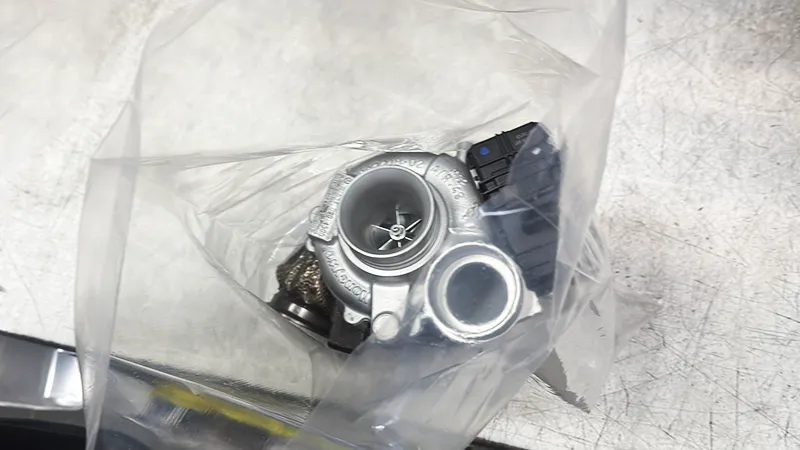 Remanufactured turbocharger resting inside an open protective plastic bag